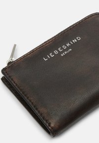 Czarny portfel z teksturowanej skóry z srebrnym zamkiem błyskawicznym i wytłoczonym logo "LIEBESKIND BERLIN" na przodzie. Kompaktowy i funkcjonalny design.