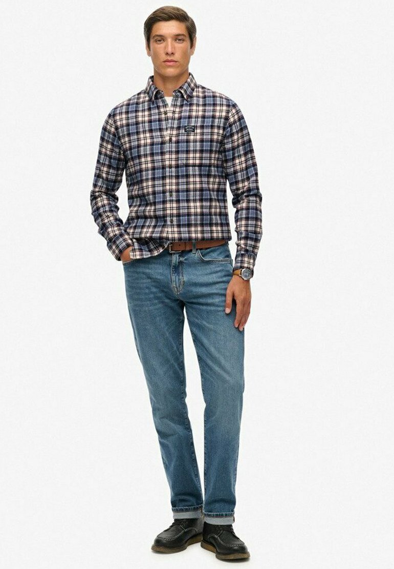 Heren geruite overhemden met knopen in navy, wit en tan; gecombineerd met lichtblauwe jeans en zwarte schoenen. Glad textuur, klassieke pasvorm en twee borstzakken.