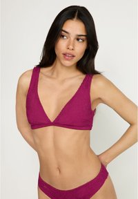 Φούξια πλεκτό μπικίνι με υφή. Διαθέτει τοπ με βαθύ V και φαρδιές τιράντες, καθώς και αντίστοιχο χαμηλό παντελονάκι.