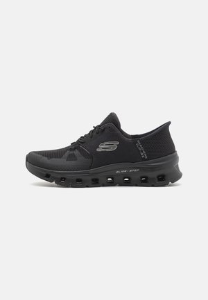 Chaussure de sport Skechers basse noire avec empeigne en maille, fermeture à lacets et semelle rembourrée étiquetée "Glide-Step" pour le confort et le soutien.