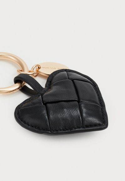 Black leather heart-shaped keychain with quilted texture, gold metal ring, and engraved tag. Compact design with a smooth finish.