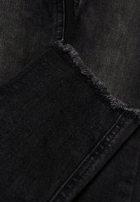 Svarte denimjeans med slitt kant, subtil tekstur og klassisk straight-leg design med kontrastsøm.