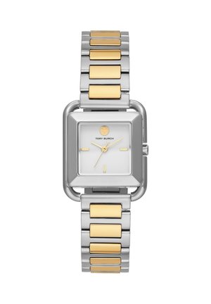 Kwadratowy srebrny zegarek z złotymi akcentami, białą tarczą, złotymi wskazówkami, minimalistycznymi indeksami i dwukolorową metalową bransoletą.