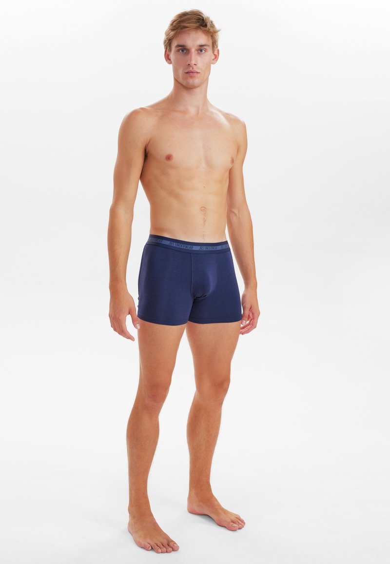 Dunkelblaue, baumwollene Boxershorts mit einem weichen Bund, anliegender Form und minimalistischer Gestaltung, ohne sichtbare Muster oder zusätzliche Akzente.