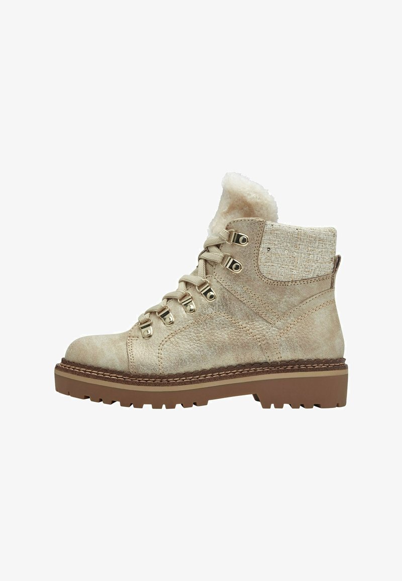 Beige pahklisi kuidus suede'ist, tehisnaha voodriga, metallist neetide, paeltega disainiga ja karmi kummitaldiga.