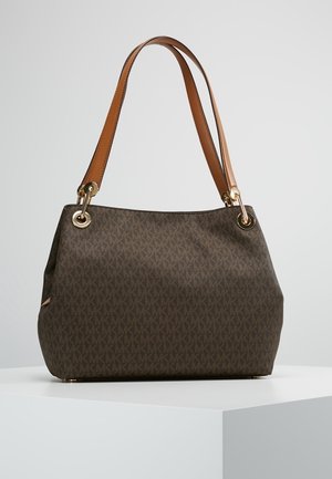 Sac à main de créateur marron avec motif répétitif de logo, lanières d'épaule en cuir beige et éléments métalliques dorés, posé sur une surface blanche.