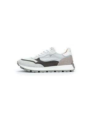 Zapatillas de tela blanca con detalles en ante gris y un diseño negro, que cuentan con una suela blanca gruesa y una suela texturizada.