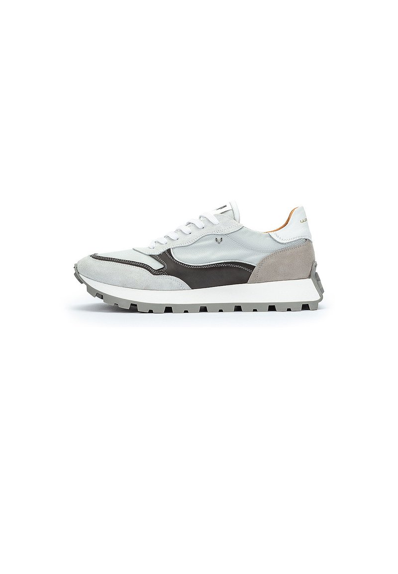 Zapatillas de tela blanca con detalles en ante gris y un diseño negro, que cuentan con una suela blanca gruesa y una suela texturizada.