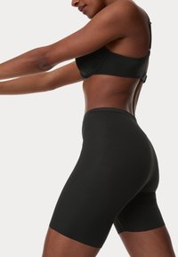 Pantalones cortos de tiro alto negros confeccionados con un material suave y elástico, con un diseño ajustado que llega hasta la mitad del muslo.