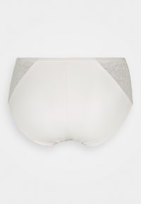 Jasnobeżowa bielizna z gładką tkaniną z przodu i koronkowymi detalami po bokach z tyłu. Elastyczny pas, średni stan oraz bezszwowy krój.