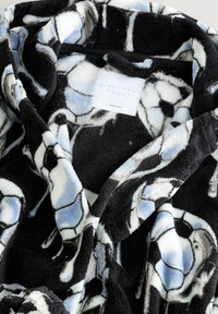 Svart fleece-kappa med ett mönster av fotbollar i vitt, blått och grått. Mjuk textur med stor krage och etikett som visar "NIGHTWEAR by NEXT."