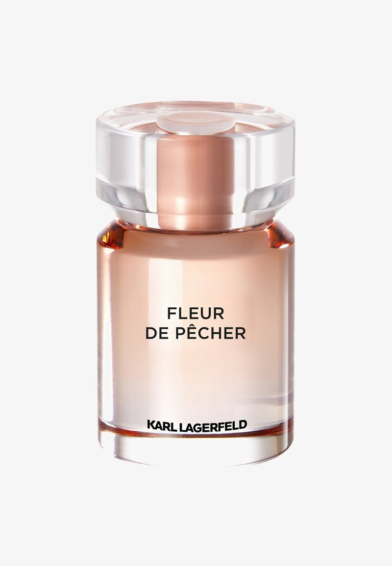 Heldere glazen parfumfles met een ronde, transparantedop. Bevat een lichtroze vloeistof. Het etiket leest "FLEUR DE PÊCHER" en "KARL LAGERFELD."