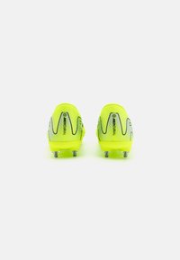 Neon yellow soccer cleats with a textured mesh upper, silver accent lines, and five metal studs on the outsole for traction.
