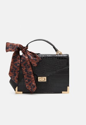 Zwarte handtas met krokodillenstructuur, gouden accenten, bovenhandvat en een bruine sjaal met luipaardprint die aan het handvat is vastgebonden.