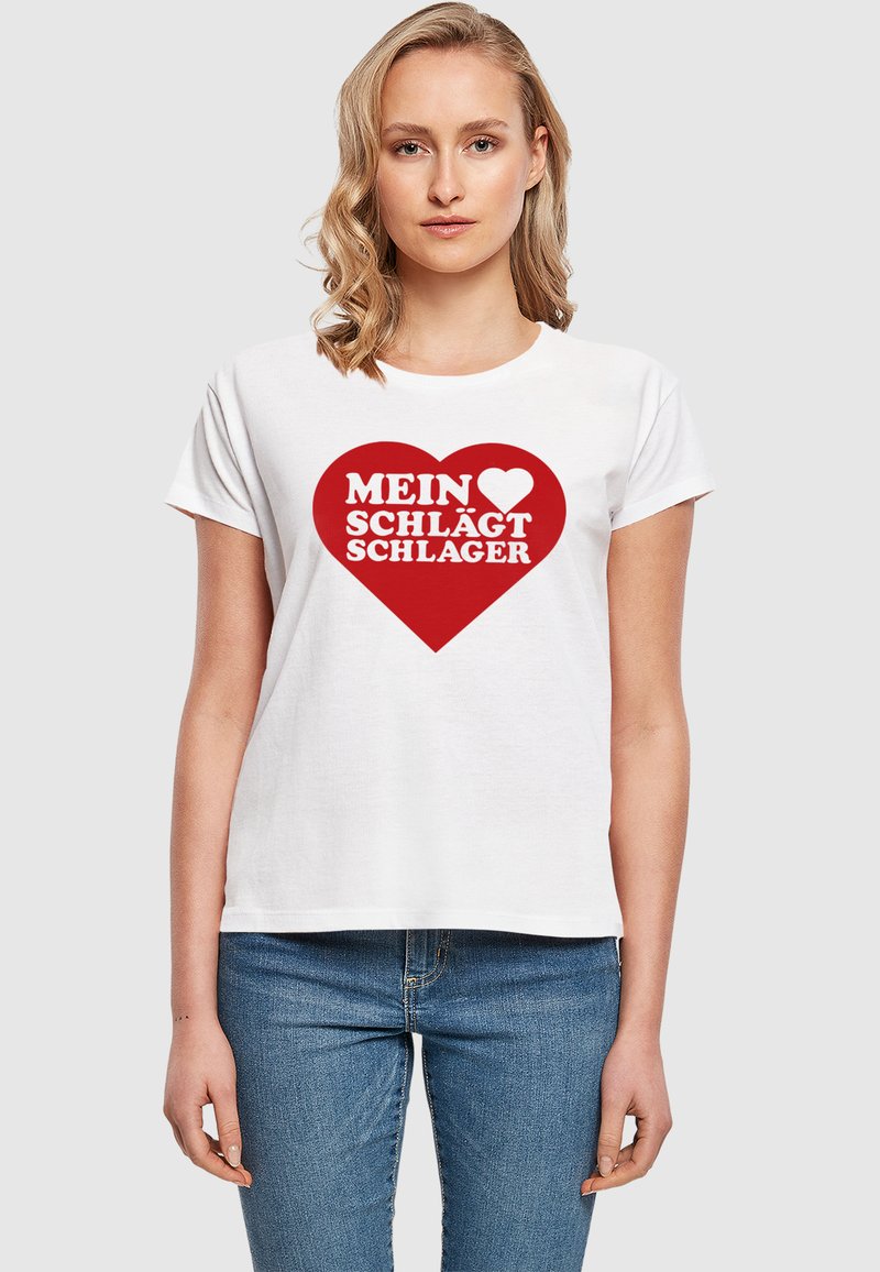 Tricou alb din bumbac, cu o croială lejeră, având un grafic îndrăzneț în formă de inimă roșie, cu textul "MEIN ♥ SCHLÄGT SCHLAGER" scris cu litere albe.