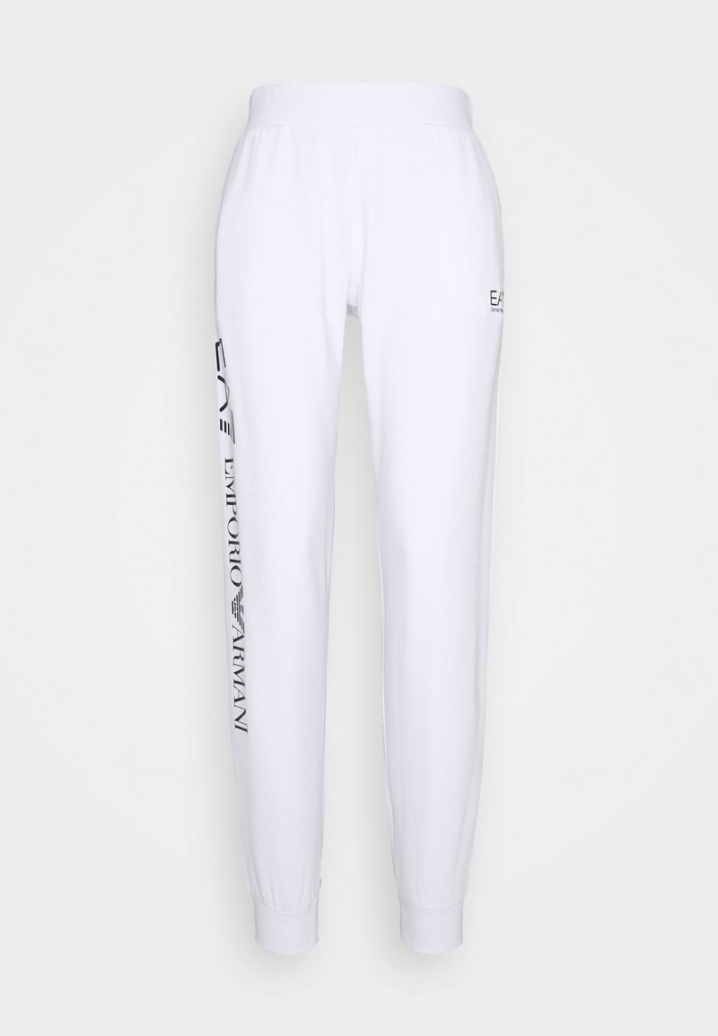 Pantalon de survêtement blanc avec taille élastique. Présente un texte imprimé noir sur la jambe gauche. Coupe ajustée avec ourlets resserrés. Texture de tissu douce.