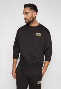 Sudadera negra de mezcla de algodón, con cuello redondo, puños acanalados, que presenta el logo 'JUVENTUS MILLE897' en blanco y amarillo en el pecho.