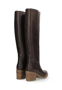 Botas altas de cuero marrón con tacón grueso, que presentan detalles de costura sutil y una textura suave en el cañón y el pie.