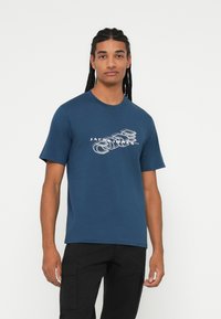 T-shirt a maniche corte blu navy in cotone, con una stampa grafica bianca con testo "JACK & JONES" e disegni geometrici sul davanti.