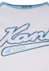 Biela rebrovaná tričko s modrým logom "Kani" s čiernym obrysom a nápisom "est. 1989" v zakrivenej modrej vlajke pod textom.