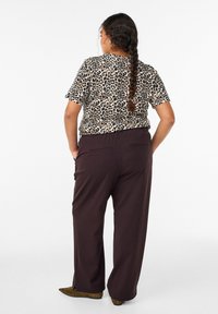 Korte mouw top met luipaardprint gecombineerd met donkerbruine, loszittende broek met zijzakken en een casual silhouet.