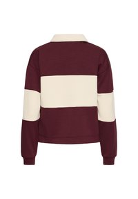 Sudadera a rayas en color marrón y crema con cuello, que presenta un diseño corto y puños acanalados. Tejido suave y texturizado.