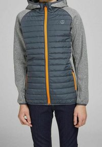 Padded jacket o ciemnoszarym korpusie i jasnoszarych rękawach. Posiada pomarańczowy zamek, kaptur oraz logo na klatce piersiowej.