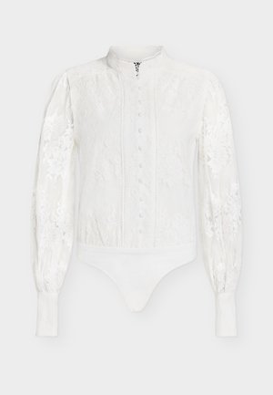 Body cu mâneci lungi din dantelă albă, cu guler înalt, nasturi frontali acoperiți cu material, model floral și manșete strâmte.