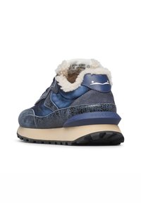 Sneaker blu con texture in pelle screpolata, suola beige, battistrada nero e rivestimento in pile bianco visibile intorno al colletto della caviglia.