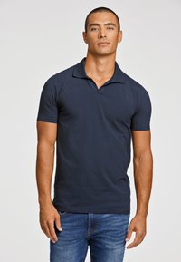 Polo de color azul marino con cuello, mangas cortas y un diseño ajustado. Fabricado con una tela suave con una textura sutil.