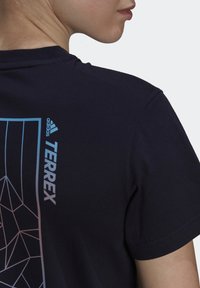 Černé bavlněné tričko s logem "TERREX" v modré barvě a geometrickým vzorem v gradientních barvách na zadní straně, kulatý výstřih, krátké rukávy.
