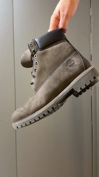 Brun skinnstøvel med polstret svart krage, metallhull og en robust gummisåle med dype mønstre.