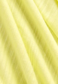 Lysegult stof med en blød, struktureret overflade. Materialet virker let og svagt gennemsigtigt med subtile horisontale striber.