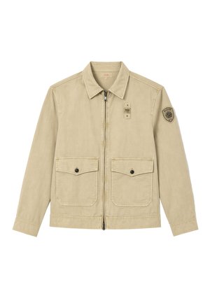 Giacca beige con zip, colletto appuntito, due tasche frontali con patta e bottoni e un patch logo circolare sulla parte superiore della manica sinistra.