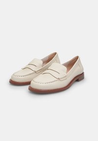 Loafers din piele crem cu vârf cusut, două curele frontale și o talpă din cauciuc maro. Textură netedă și design clasic pentru o purtare versatilă.