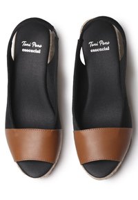 Wedges negras abiertas por delante con una tira de cuero marrón en la parte frontal. Presentan una plantilla texturizada y una suela intermedia de yute trenzado.