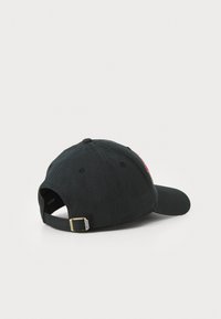 Svart baseballcaps laget av bomull med buet skygge, justerbar stropp og en logo brodert på siden. Med et rent design.
