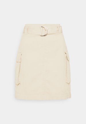 Jupe beige longueur genou avec grandes poches latérales et ceinture assortie avec boucle D en argent.
