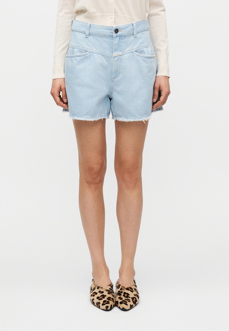 Γαλάζια τζιν σορτς με ξεφτισμένο τ ελείωμα, διαθέτει δύο εμπρόσθιες τσέπες, φερμουάρ με κλείσιμο με κουμπί και άνετη εφαρμογή.