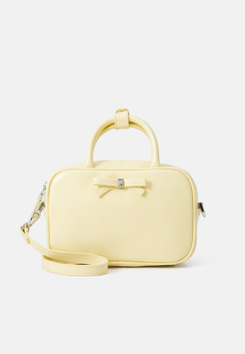 Sárga, strukturált kézitáska sima bőrből. Fekete masni díszítés, felső fogantyú és leválasztható vállpánt jellemzi.