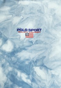 Light blue tie-dye sweatshirt made of cotton, featuring "POLO SPORT" and "RALPH LAUREN" embroidered in navy and red with an American flag accent.