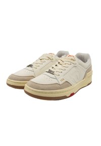 Beige und cremfarbene Sneakers mit Obermaterial aus Wildleder und Leder, perforierter Zehenpartie, Schnürdesign und Gummisohle mit roten und gelben Akzenten.
