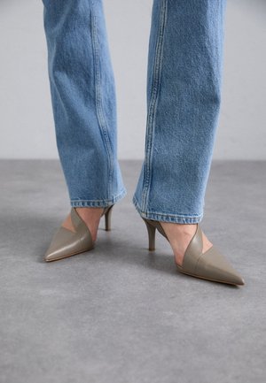 Scarpe con tacco a punta grigia con un design a scollo a V, dotate di un tacco stiletto sottile. Indossate con jeans dritti blu chiaro.
