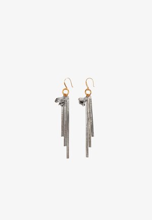 Boucles d'oreilles en métal avec des crochets dorés, présentant de longues mèches argentées et des accents en forme de fleur en haut. La texture est lisse avec une finition polie.