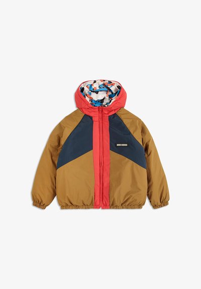 Chaqueta cortavientos con capucha roja, diseño a franjas en marrón y azul marino, puños elásticos y un forro colorido con un patrón de motivos juguetones.