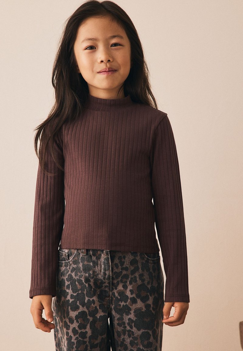 Top marrón de manga larga con textura acanalada y cuello alto, combinado con pantalones grises con estampado de leopardo. La tela parece suave y ajustada.