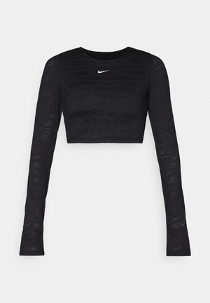 Crop top noir à manches longues avec un motif texturé du logo Nike, présentant un col rond et un tissu lisse.