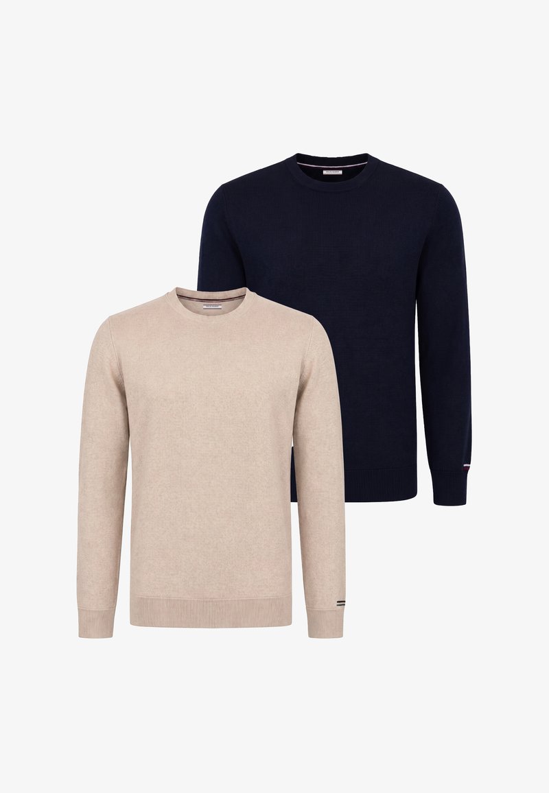 Deux pulls unis à manches longues et col rond, un beige devant et un bleu marine foncé derrière, tous deux avec des poignets et des ourlets côtelés.