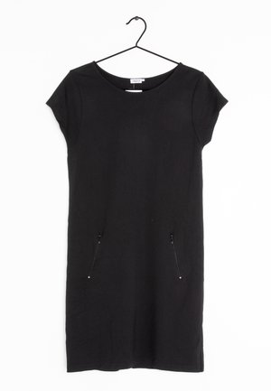Zwarte jurk met korte mouwen, een ronde hals en twee voorzakken met rits, hangend aan een zwarte hanger tegen een witte achtergrond.