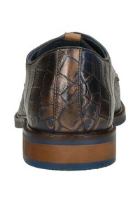 Bruine gegraveerde leren schoen met een gestructureerd oppervlak, ronde neus en een houten hakaccent. Heeft een marineblauwe zool.